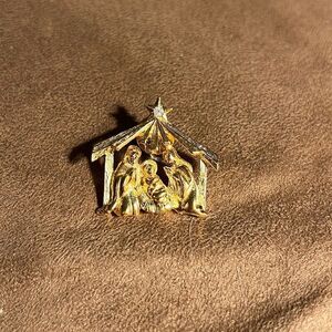Live nativity gold brooch.